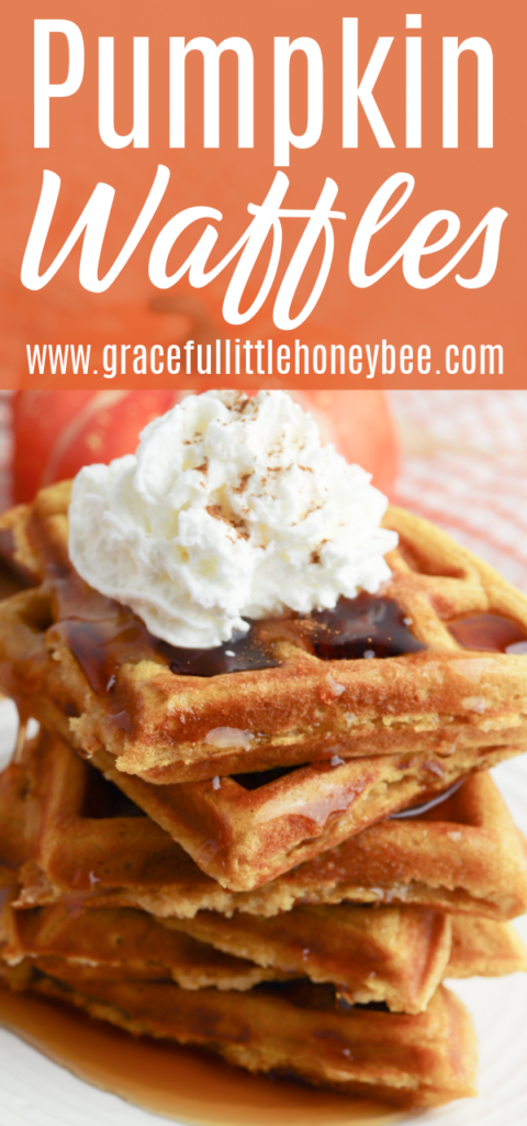 A stack of pumpkin waffles with whipped cream on top.