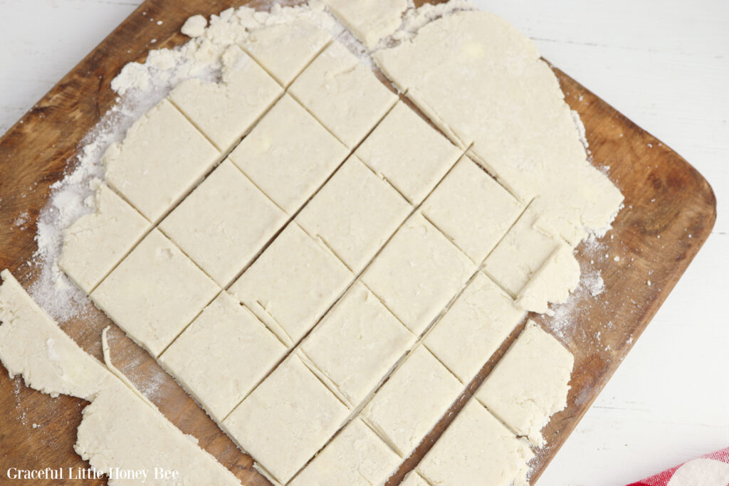 Dumpling dough rolled out and cut into squares.
