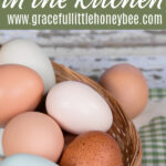 A basketful of blue, white and brown eggs with a green and white gingham towel in the background.