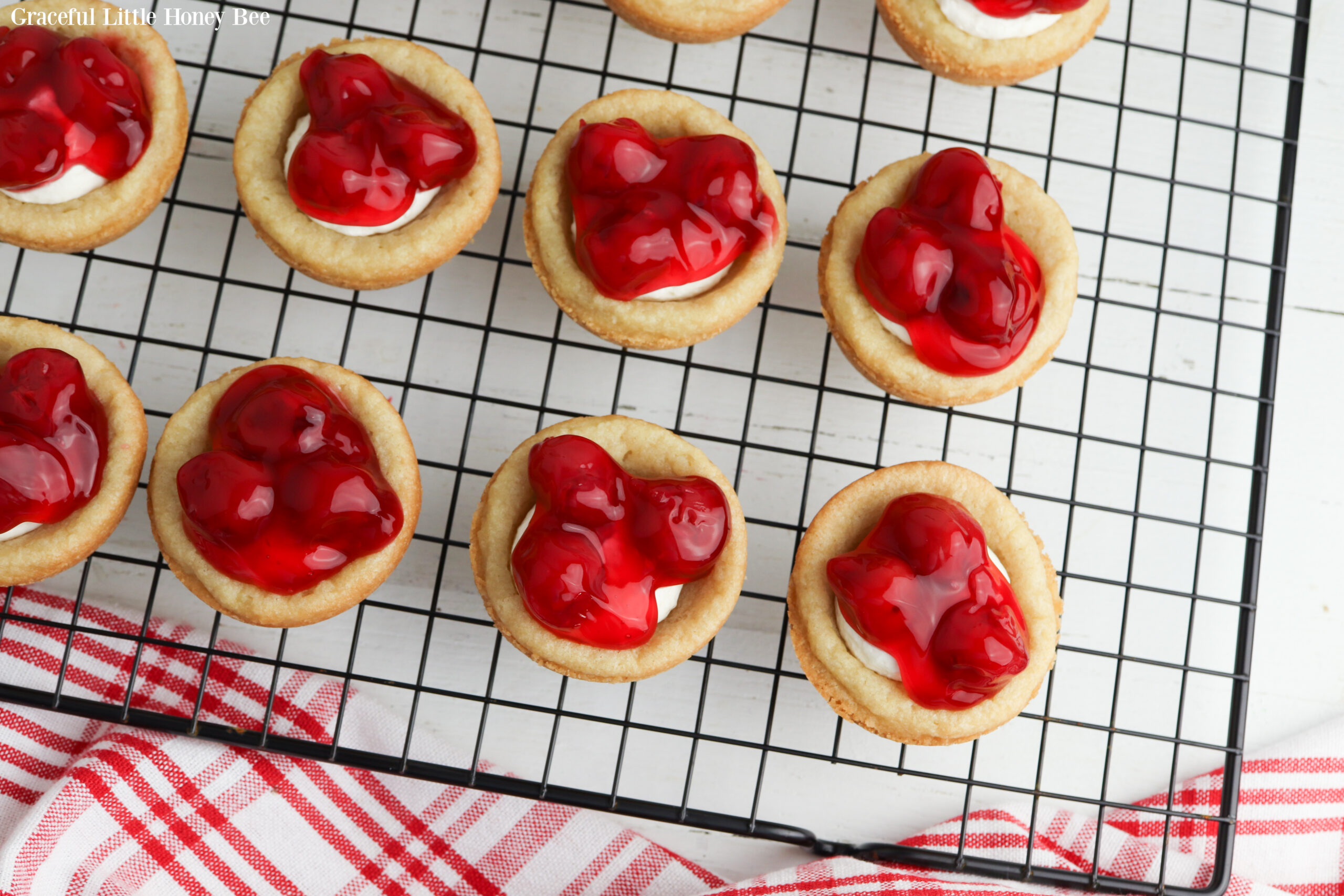 Mini Cherry Cheesecakes sitting on a wire cooling rack.