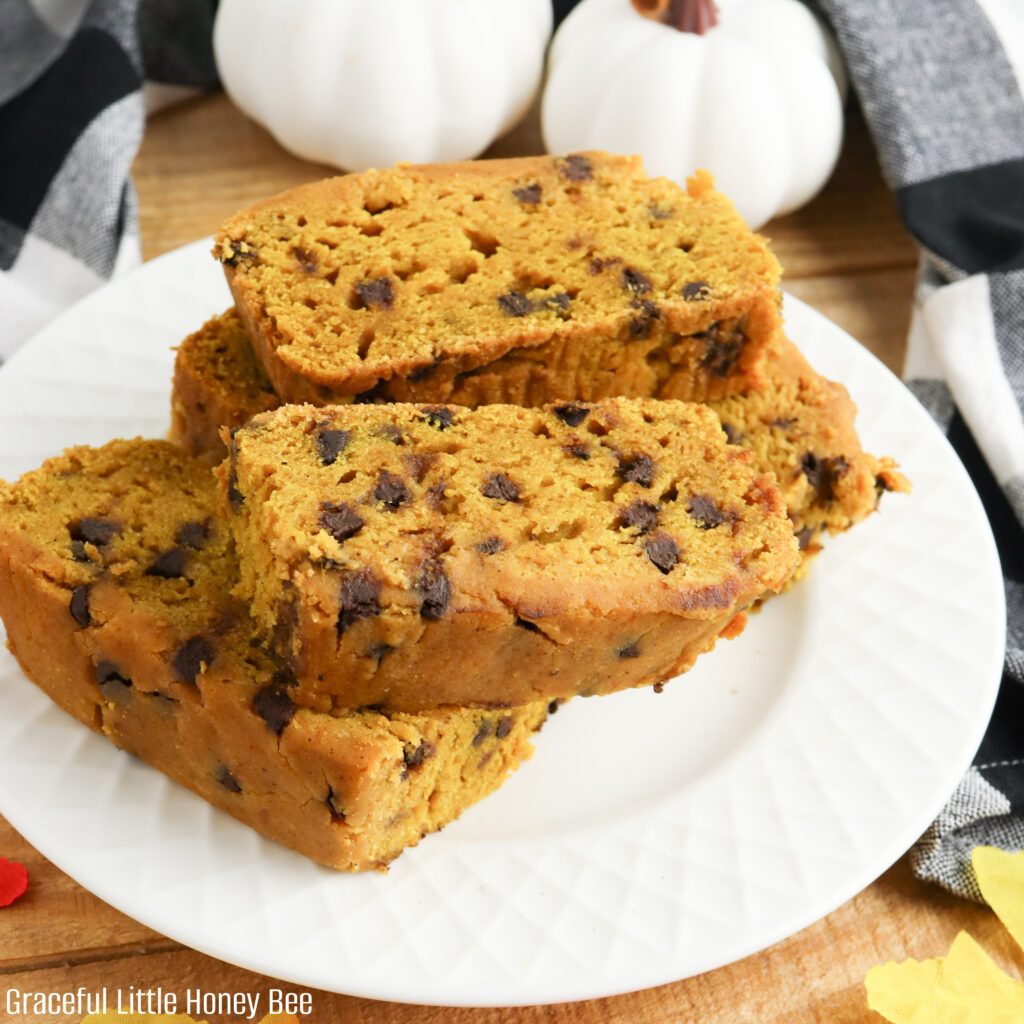 Pumpkin bread sliced and stacked on a white plate.