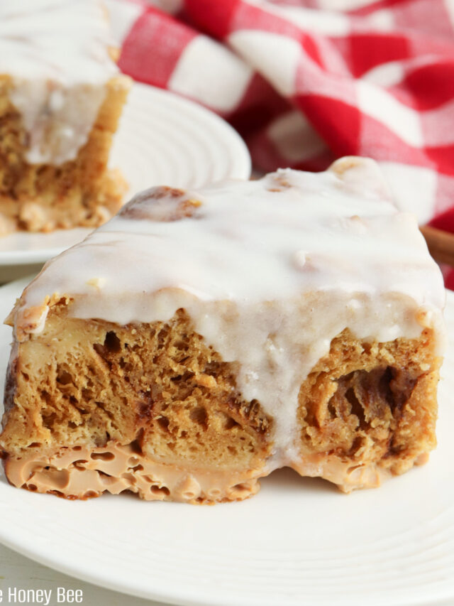 Slice of Cinnamon Roll Casserole on a round white plate.