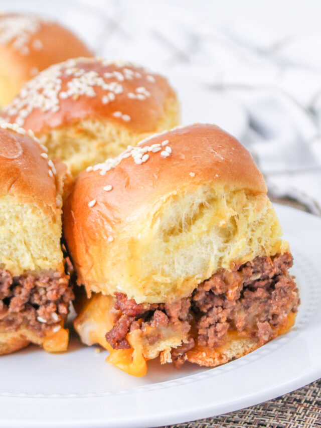 Three sliders sitting on a white plate.