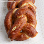 Close up of a golden brown pretzel, sprinkled with salt.