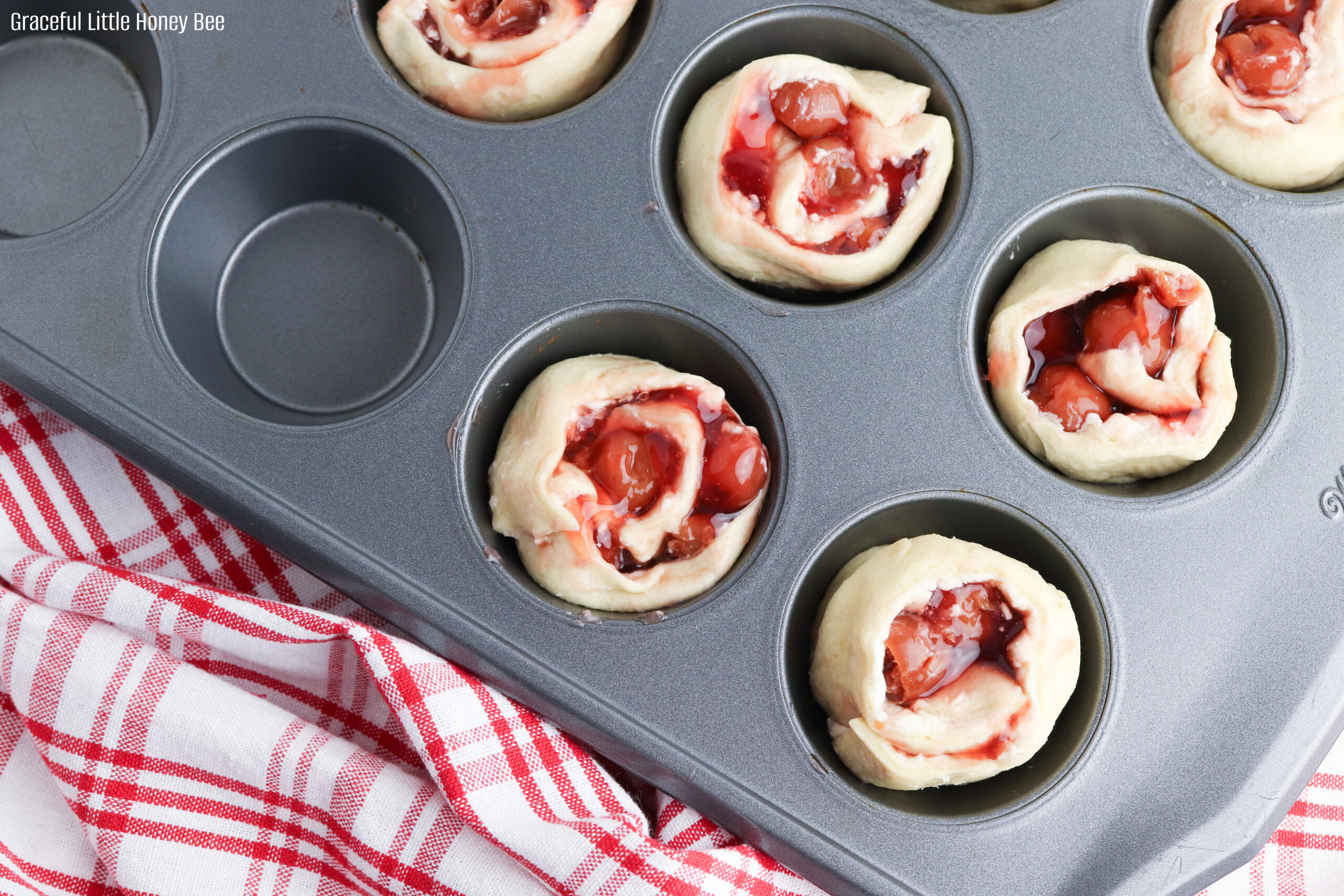 Cherry Danish Cups in a muffin tin before going into the oven.
