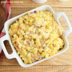 A close up on crack corn casserole in a square white dish.