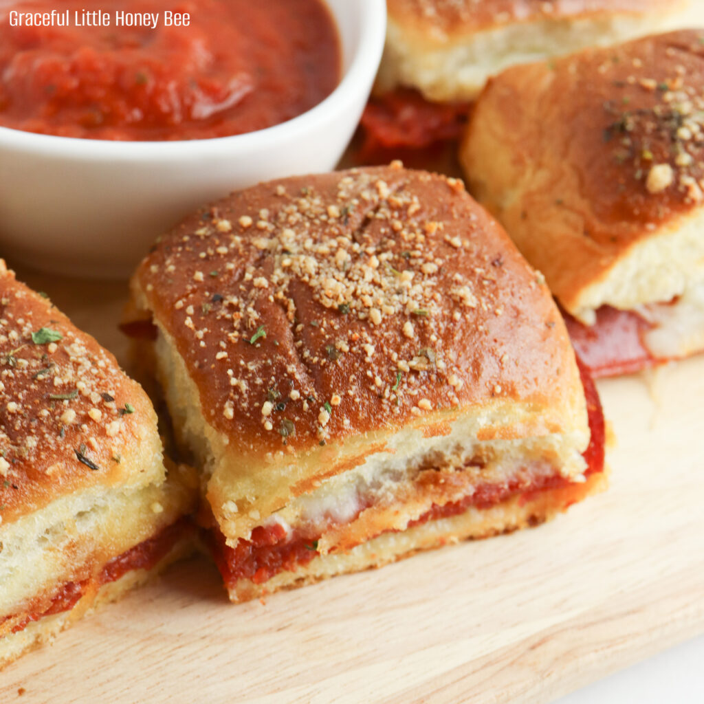 These Pepperoni Pizza Sliders are made with Hawaiian rolls, mozzarella cheese and sliced pepperoni, then slathered with butter and baked in the oven until golden brown.