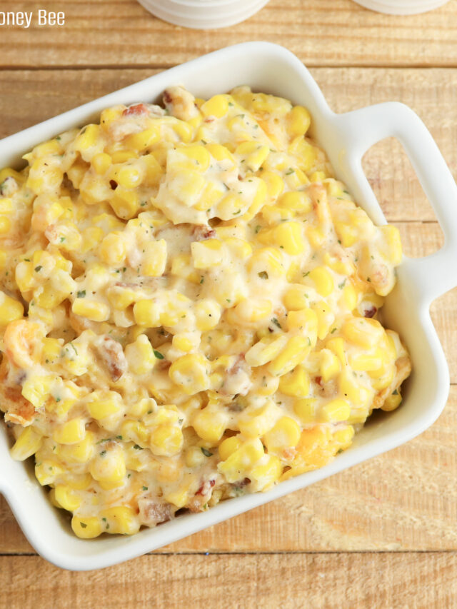 A close up on crack corn casserole in a square white dish.