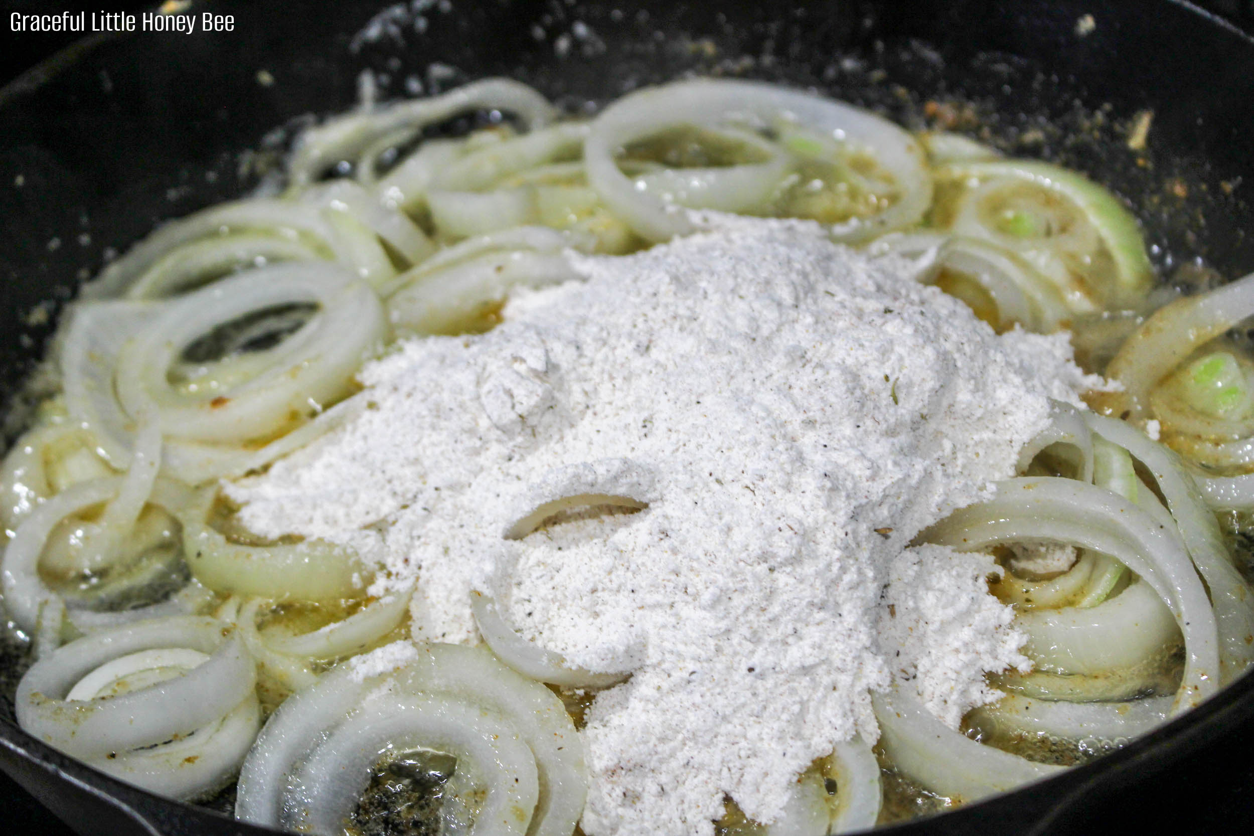 Sliced onions and flour in cast iron skillet.