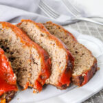 Meatloaf slices on a white plate.