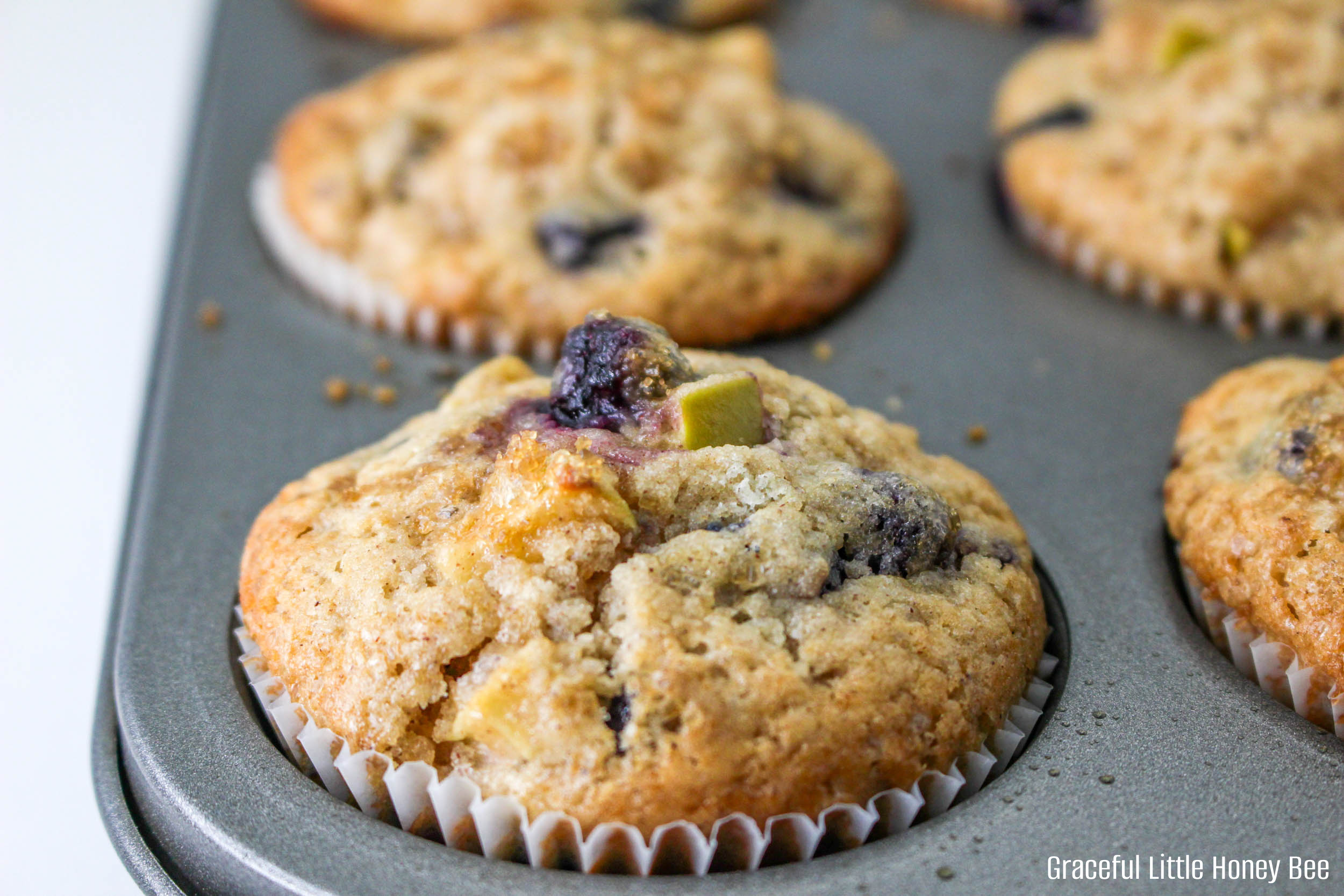 Blueberry apple muffins in a muffin tin.