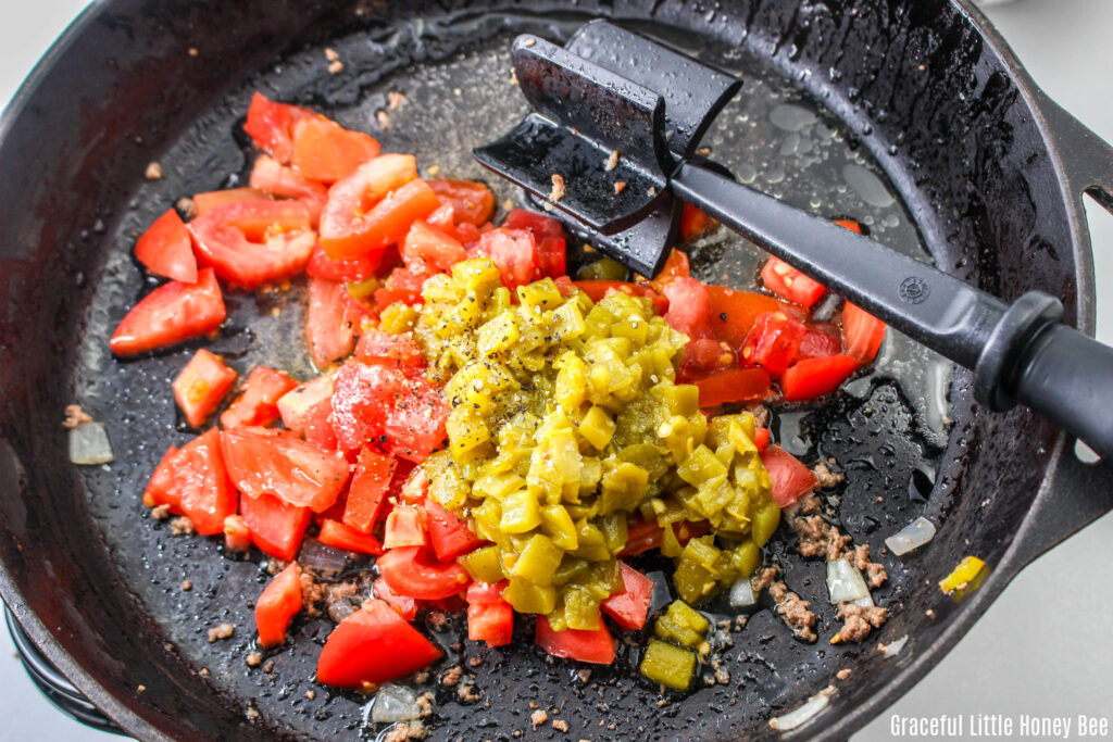 Tomatoes and green chilies in a skillet.