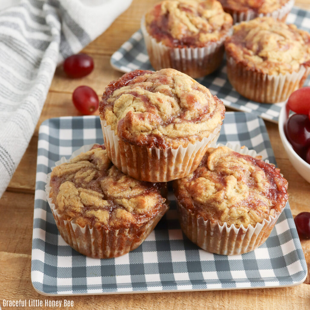 Peanut butter and jelly muffins sitting on a blue and white gingham plate.