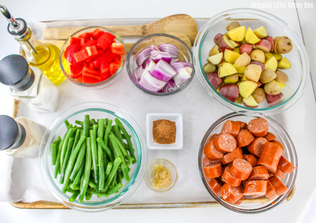 Bowls are various prepped vegetables and spices sitting on a countertop.