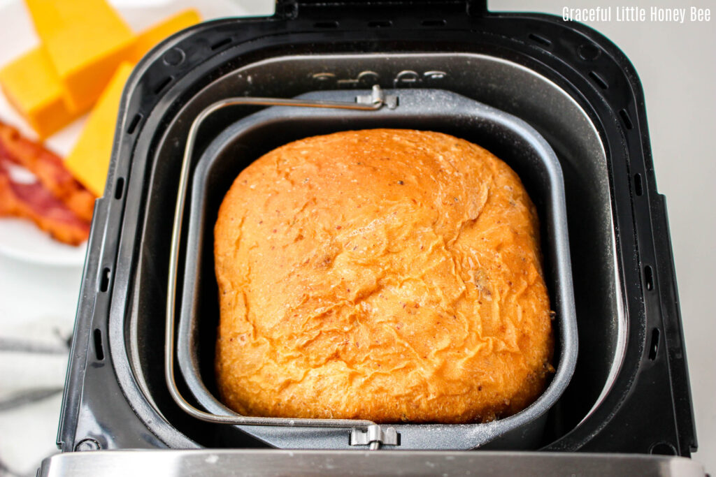 A loaf Bacon Cheddar Bread in the bread machine pan.