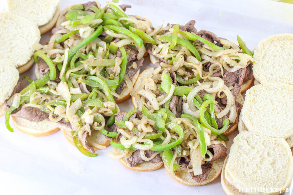 The bottoms of the slider buns topped with steak and veggies.