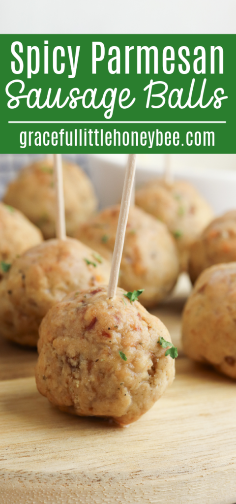 Sausage balls with toothpicks in them on a round wooden plate.