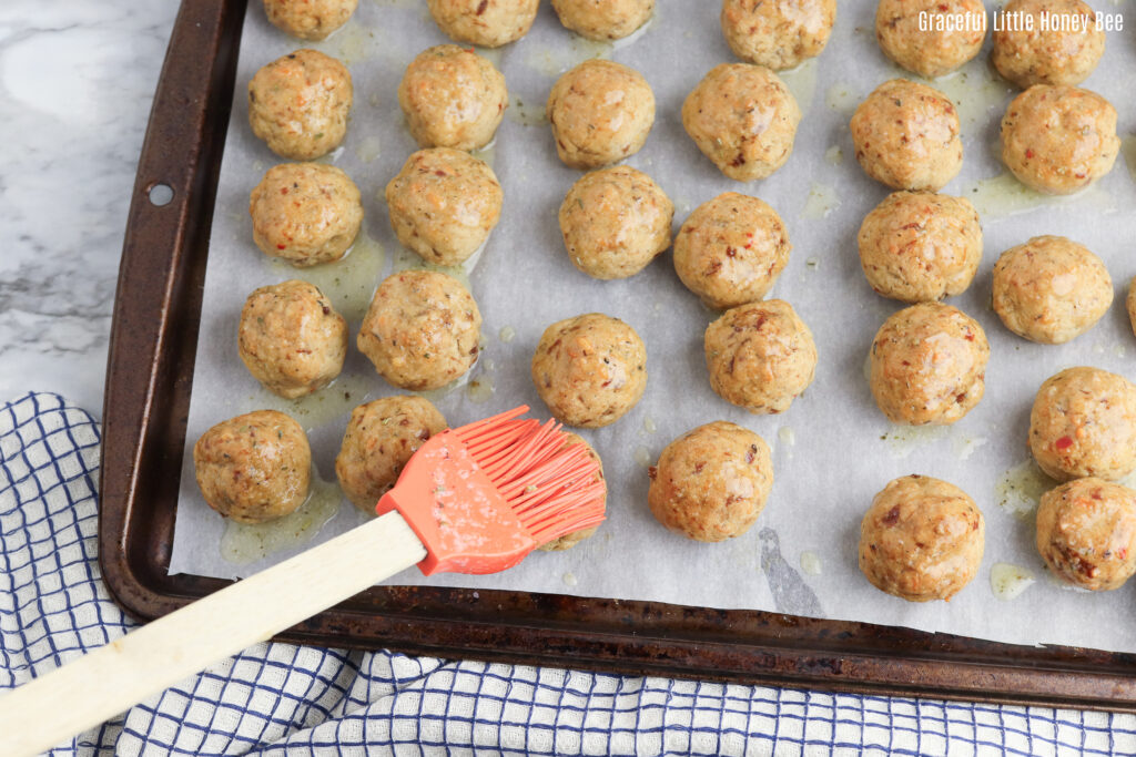 Sausage balls on a baking sheet after being cooked.