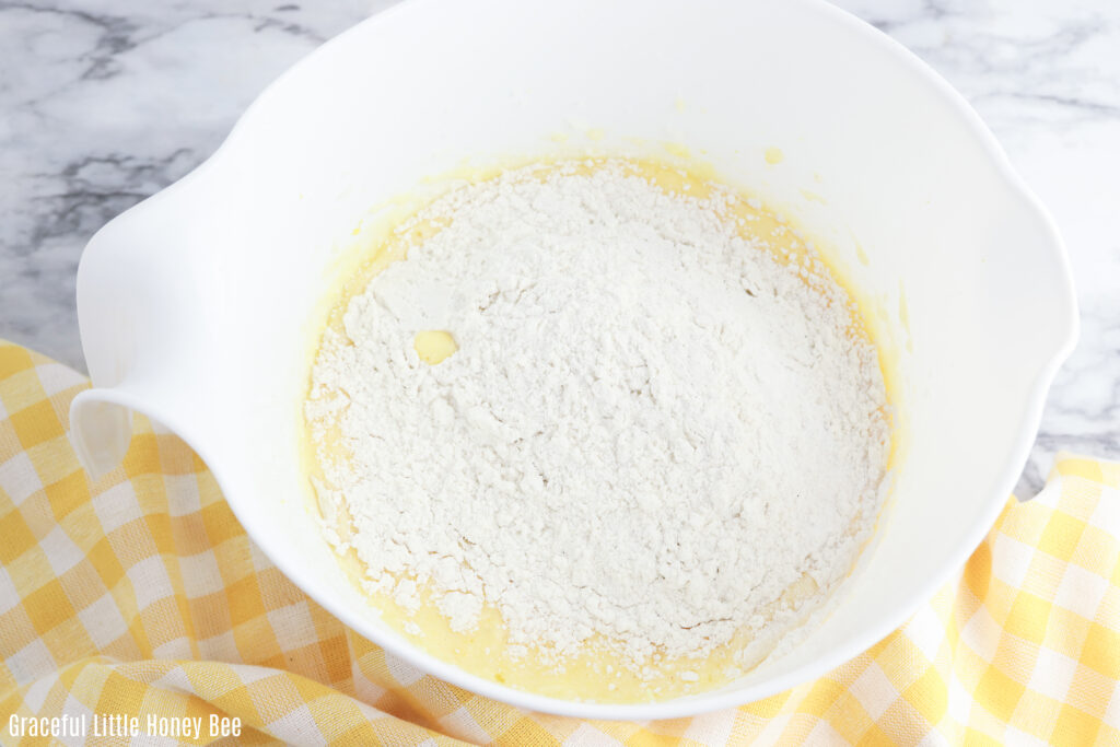 Dry ingredients mixed with batter in a white mixing bowl.