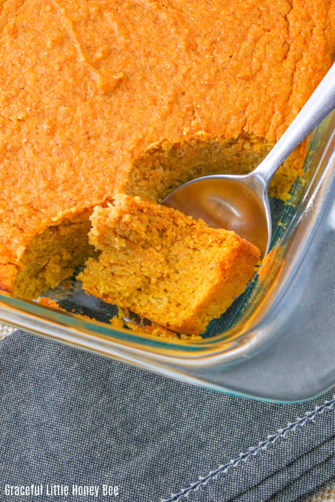 Spoonbread after being baked in the oven, with a serving removed.