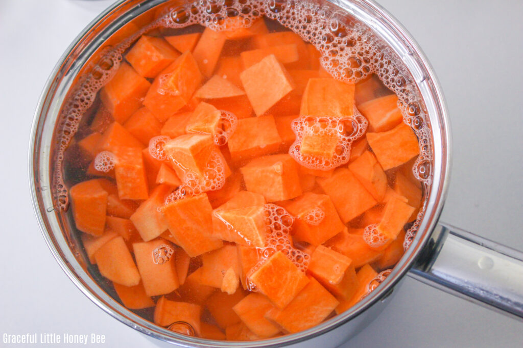 Cubed sweet potatoes in a saucepan filled with water.