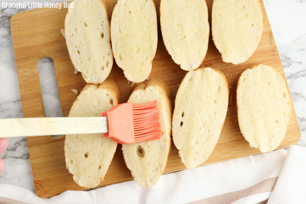 French Bread being brushed with garlic butter.