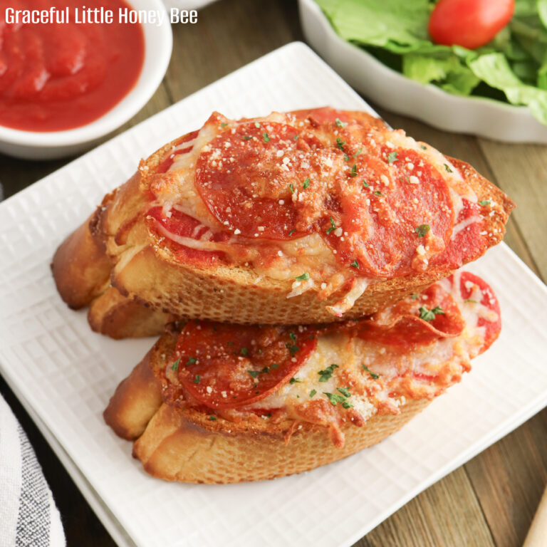 Stack of three Garlic Bread Pizzas on a white plate.