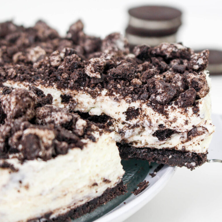 A slice of Oreo Cheesecake being removed.