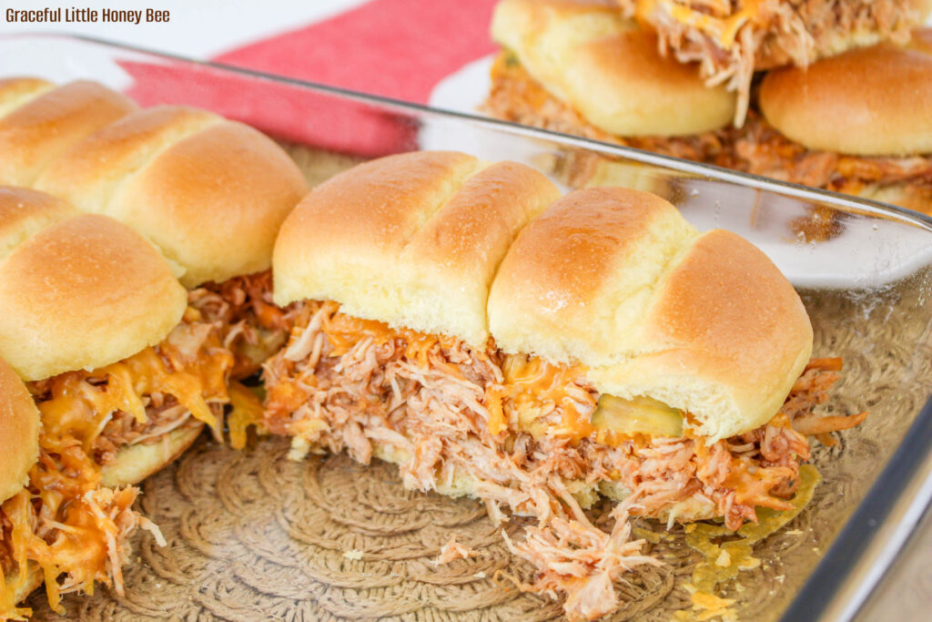 Side view of dish of bbq chicken sliders with a few missing.