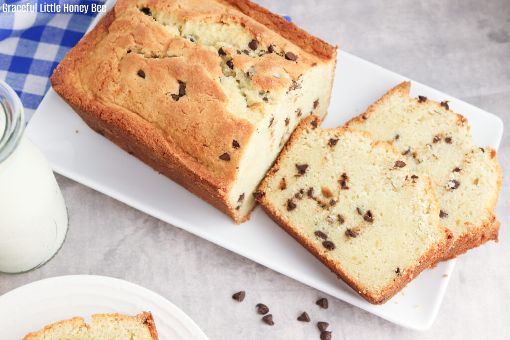 Aerial view of golden brown chocolate chip pound cake with two slices laying in front.