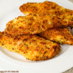 A pile of air fried Parmesan crusted chicken sitting on a white plate.