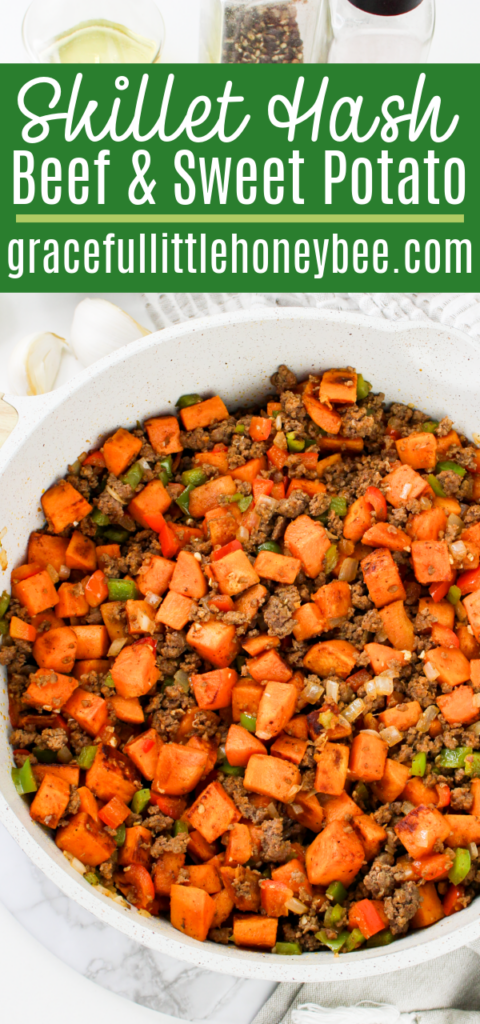 Close up view of beef & sweet potato hash in a white skillet.