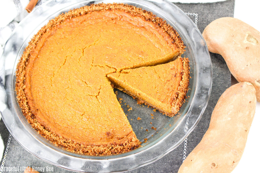 Aerial view of sweet potato pie with a slice missing.