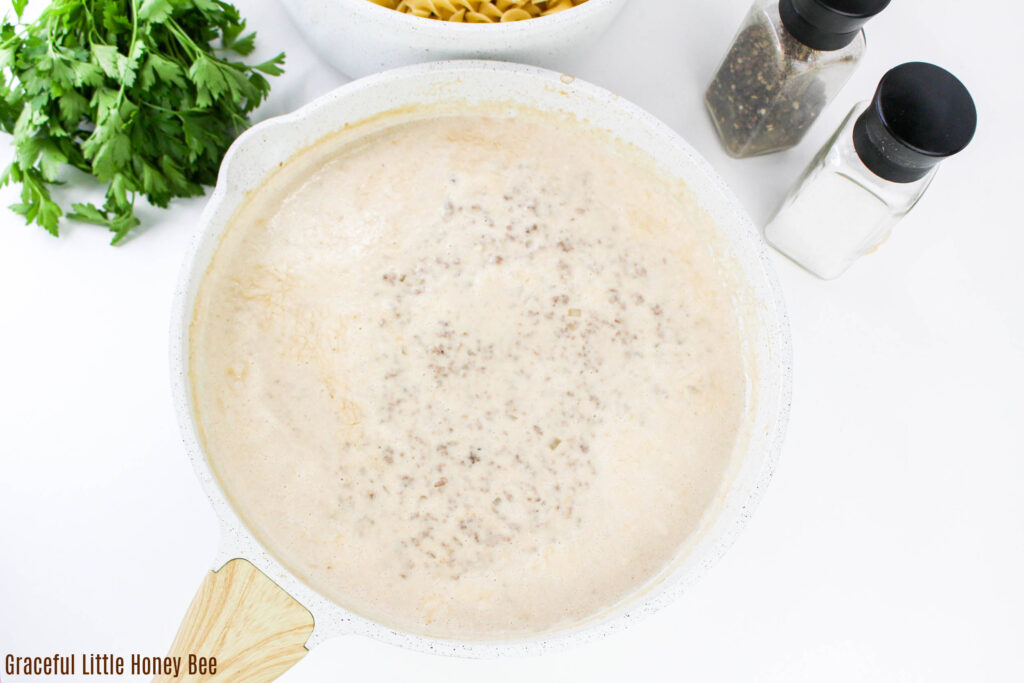 Ground beef and cream sauce in a skillet.