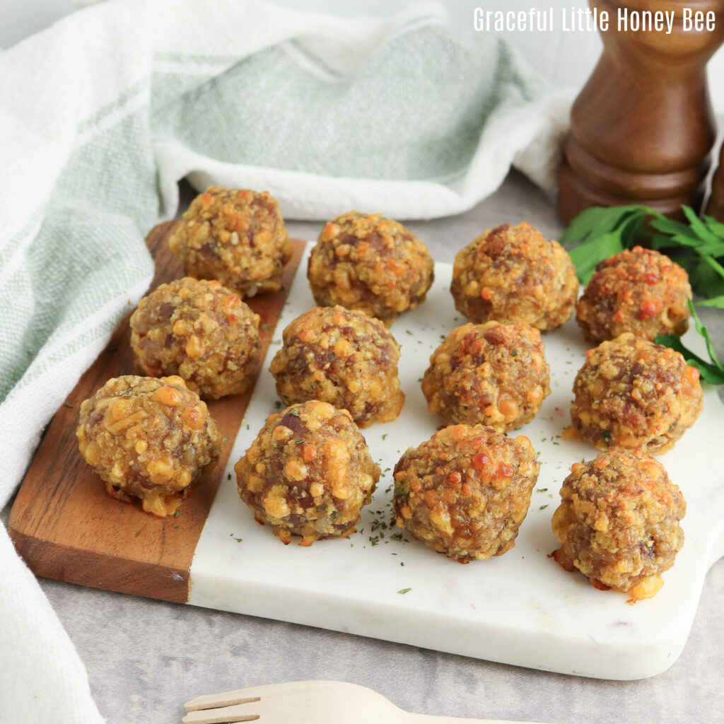 Golden brown sausage balls sitting on a small board.