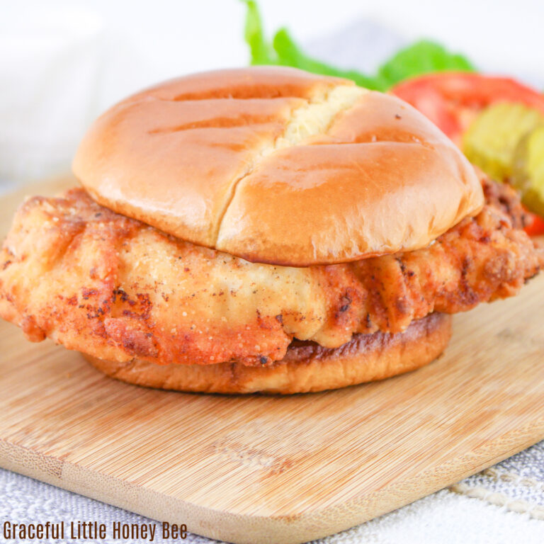 Buttermilk fried chicken sandwich sitting on a cutting board.