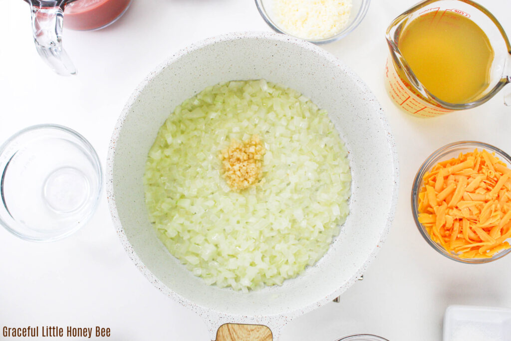 Onions and garlic sauteing in a saucepan.