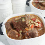 White bowl full of rich, hearty Instant Pot Beef & Barley Stew.