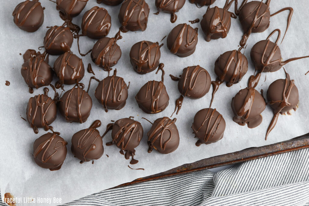 Twix Cookies sitting on a baking sheet and drizzled with chocolate.