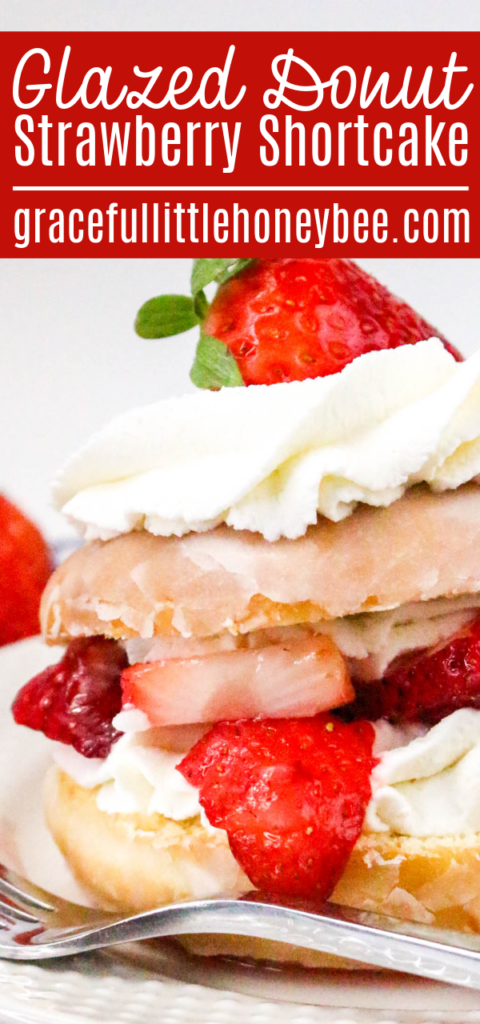 A glazed donut cut in half then filled and topped with whipped cream and strawberries.