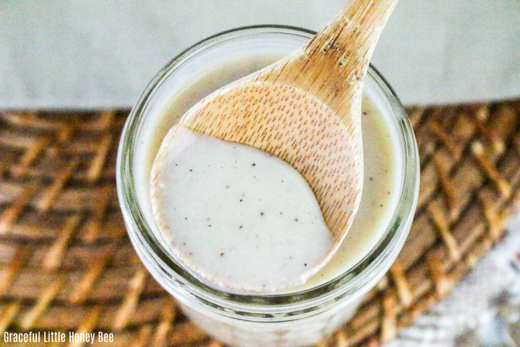 Cream of chicken soup in a mason jar being scooped out by a wooden spoon.