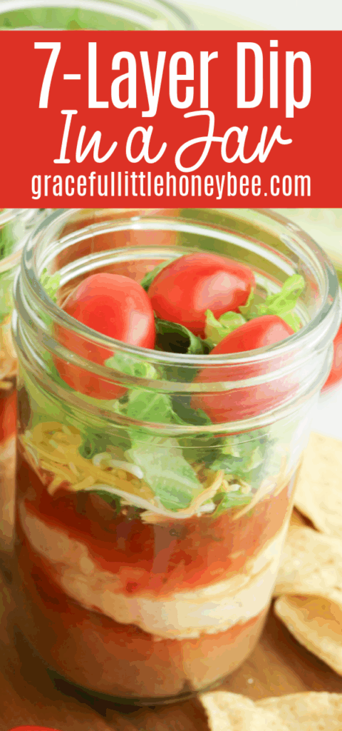 Close up view of seven layer dip in a half pint jar.