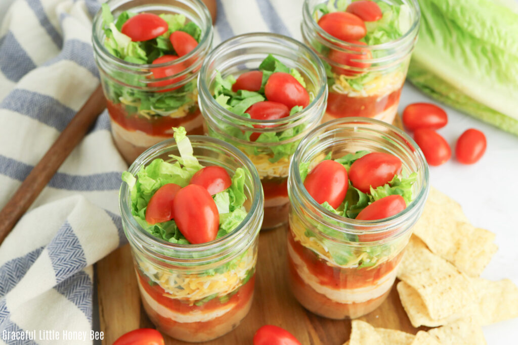 Close up view of seven layer dip in a half pint jar.