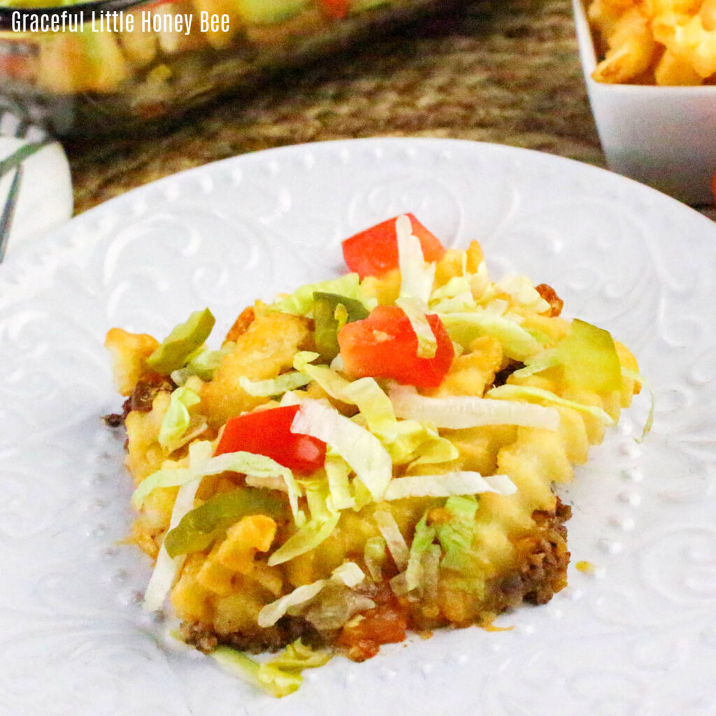 Slice of Cheeseburger French Fry Casserole sitting on a white plate.
