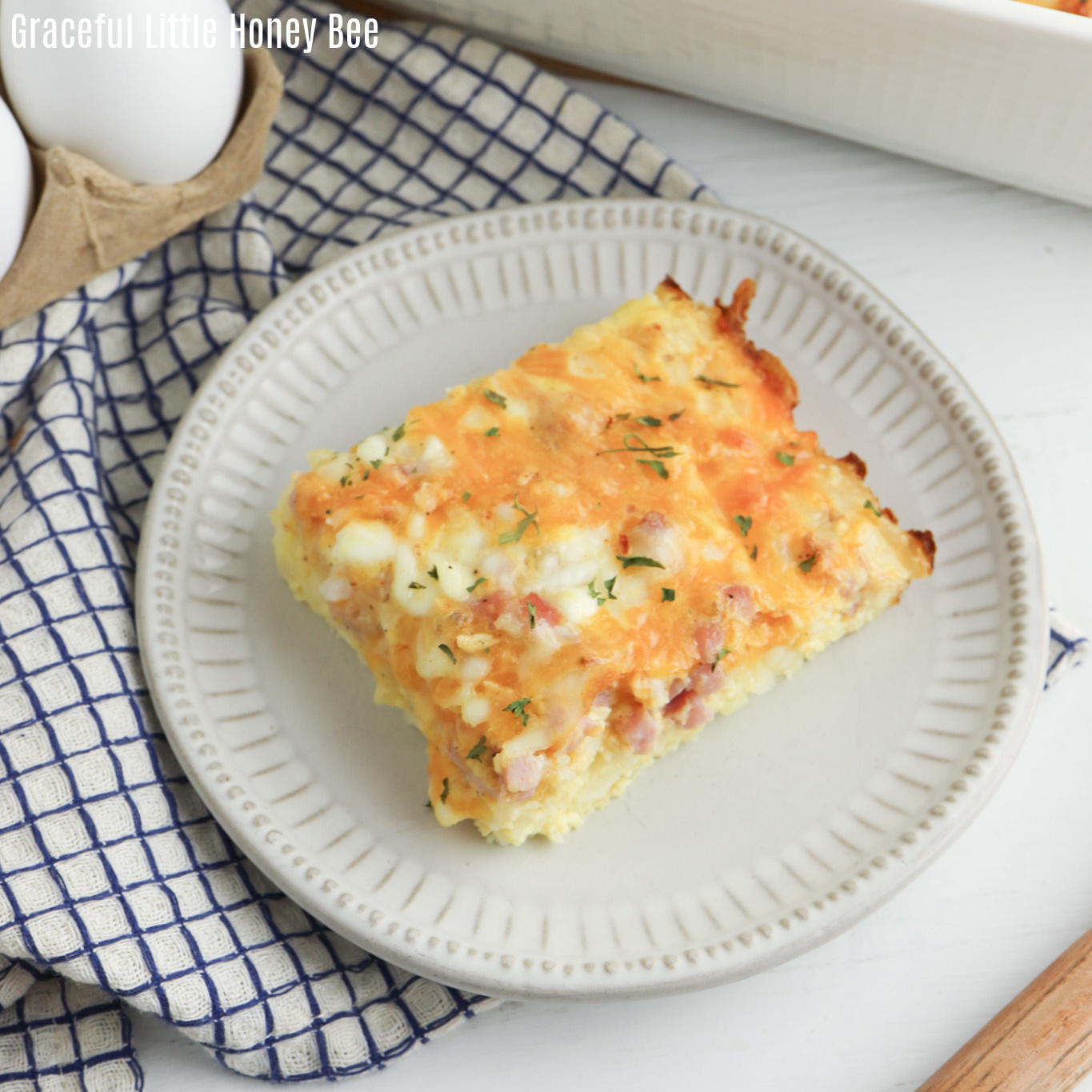 Top view of a serving of hashbrown casserole on a white plate.