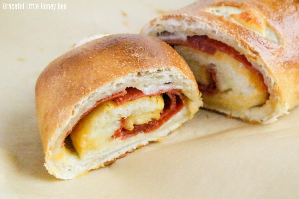 Two slices of pepperoni Stromboli sitting on parchment paper.