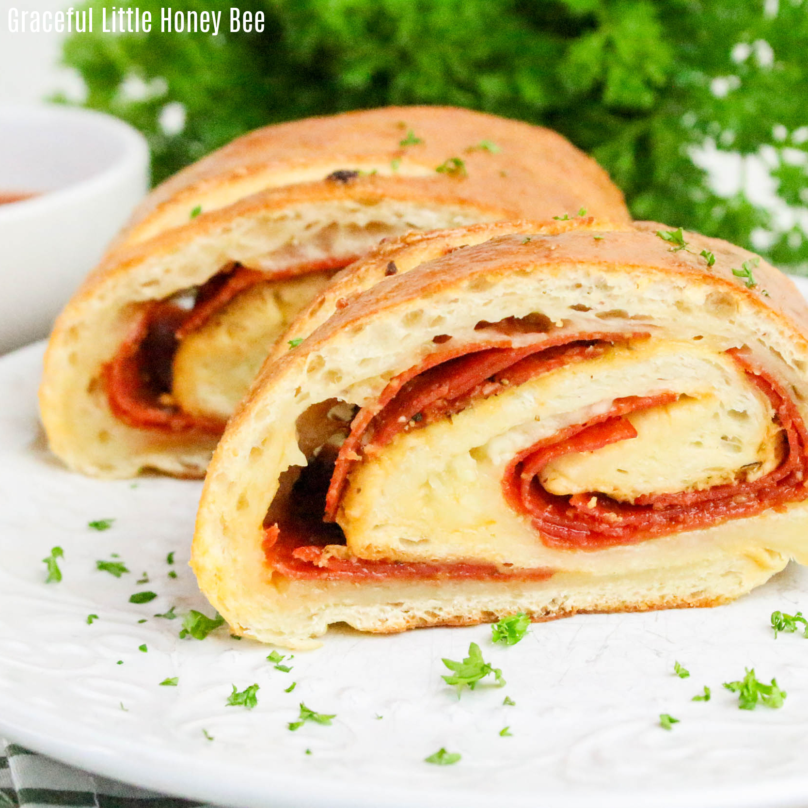 Two slices of Stromboli on a white plate, garnished with parsley.