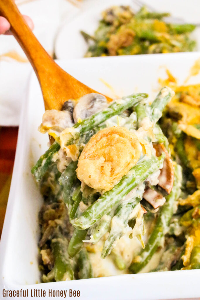 Close view of green bean casserole being spooned out of the casserole dish.
