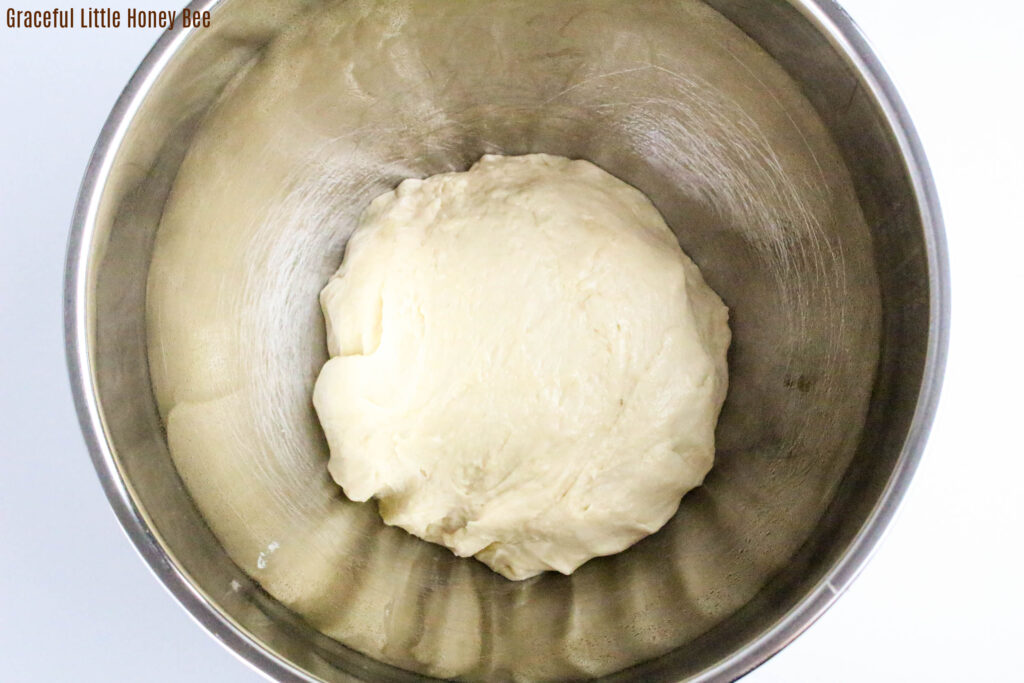 Soft dough after being kneaded in a mixing bowl.