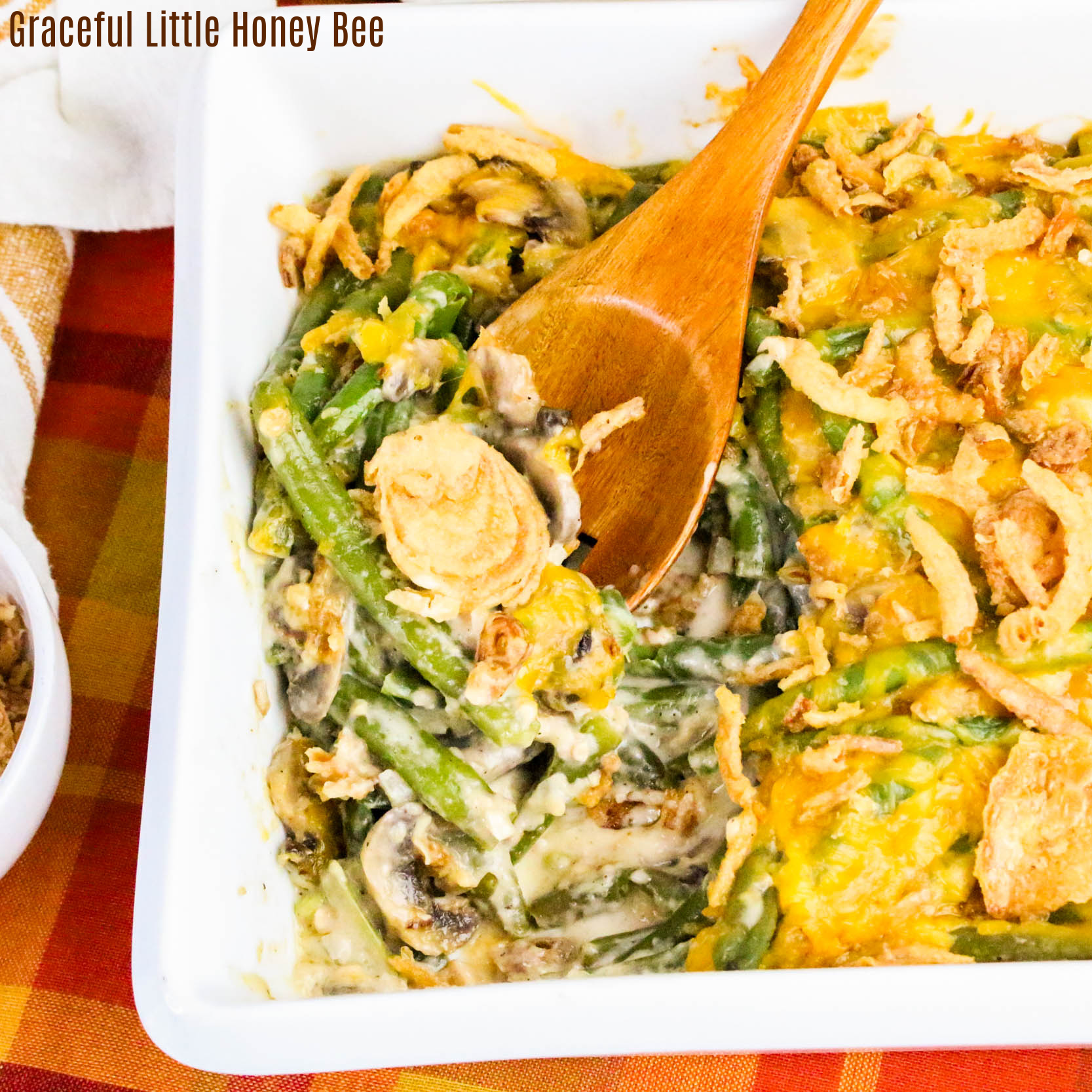 Aerial view of green bean casserole with a wooden spoon resting on the side of the dish.